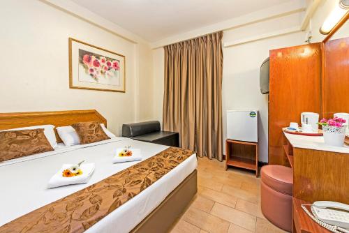 新加坡Hotel 81 Geylang的酒店客房,配有一张床铺,上面有两道菜