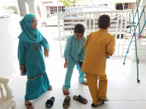 玻璃市港口Anis Homestay Kuala Perlis的一群三个孩子站在一个男人旁边