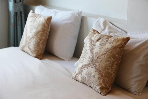 宋卡V公寓式酒店 的床上的一组枕头和白色枕头