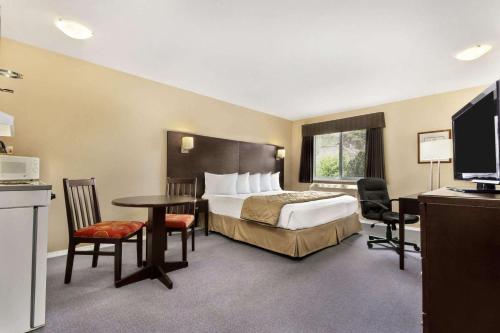西基隆拿西基洛纳速8酒店的酒店客房带一张床、一张桌子和椅子
