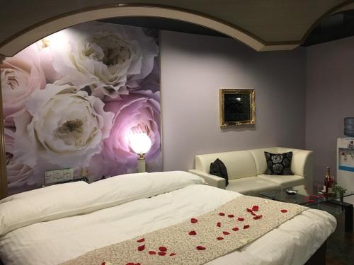 InazawaHotel Water Gate Ichinomiya (Adult Only)的卧室配有一张墙壁上涂有玫瑰的床铺。