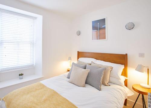 斯泰兹Host & Stay - Harbour Cottage的一间卧室配有带白色床单和枕头的床。