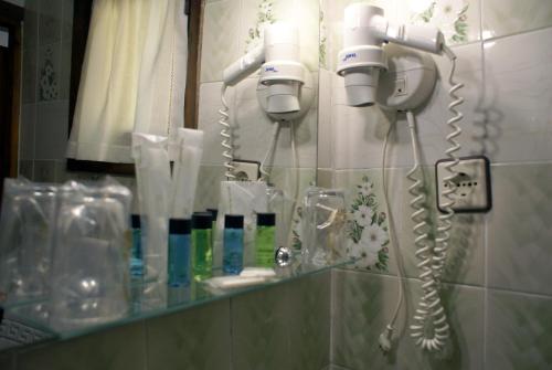 科瓦东加Casa Rural Priena的浴室镜子和墙上的几个吹风机