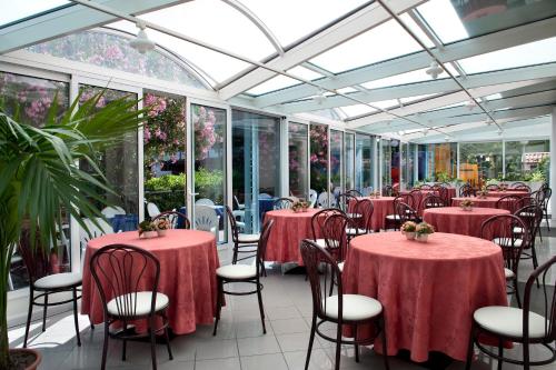 里米尼费利克斯酒店 的温室里带桌椅的用餐室