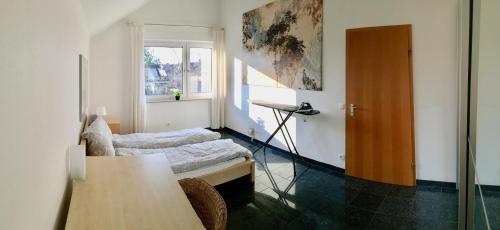 埃森Bredeneyer Straße 66A的客房设有床、桌子和窗户。