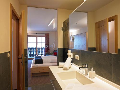 费斯Hotel Garni Frommes的一间带水槽的浴室和一间带一张床的卧室