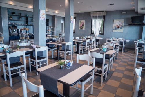 里米尼Hotel Melita Beach Experience的一间在房间内配有桌椅的餐厅