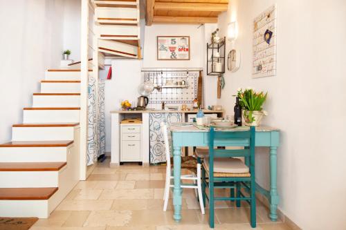 滨海波利尼亚诺TorreParadiso Holidays的厨房设有蓝色的桌子和楼梯。