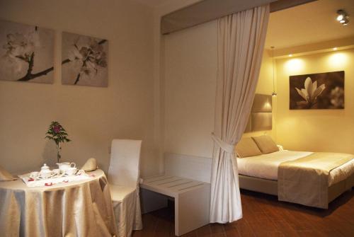卡萨诺德莱穆尔杰Il Portico Luxury B&B的酒店客房,配有床和桌子,床,还有一间客房