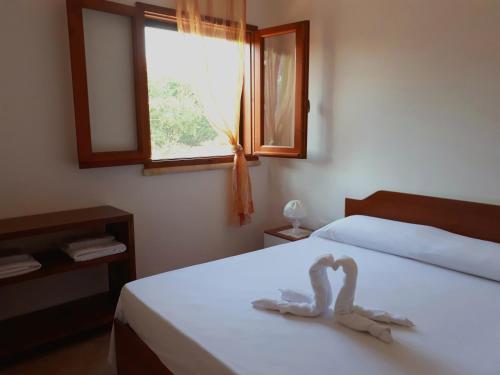 丽都玛里尼特鲁塔卡扎托度假屋的一间卧室配有一张带两个天鹅的床
