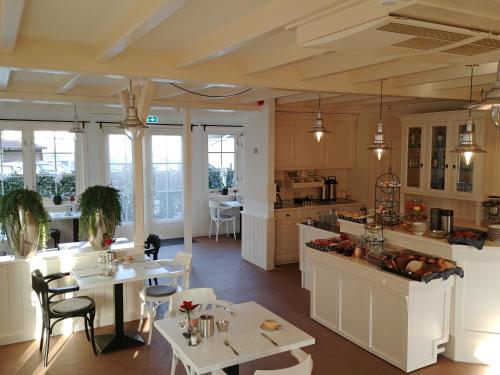 德科赫海特古登博尔杰酒店的厨房以及带桌椅的用餐室。