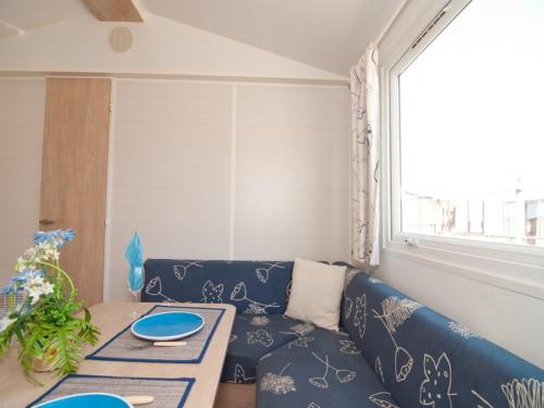 洛雷多德比罗雷露营地的客厅配有蓝色的沙发和桌子