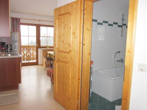 拉姆绍达赫斯坦罗塞尔公寓的一间带木门和浴缸的浴室