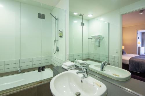 皇后镇Marina Apartments - Element Escapes的一间带水槽和镜子的浴室以及一张床