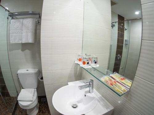 雅加达WTC芒果杜阿酒店的一间带卫生间、水槽和镜子的浴室