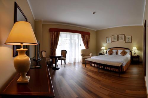 蓬塔德尔加达塔里斯曼酒店的一间卧室配有一张床和一张带台灯的桌子