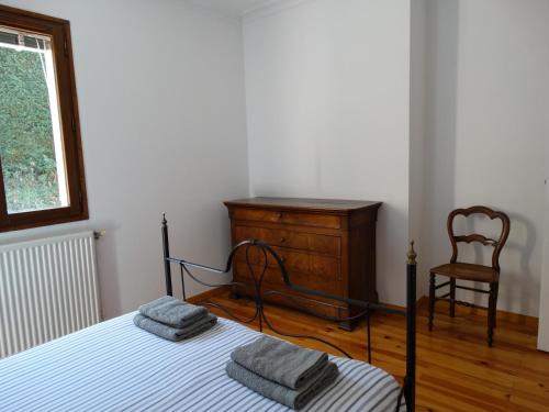 圣艾蒂安克洛斯真提安讷度假屋的一间卧室配有一张床、梳妆台和椅子