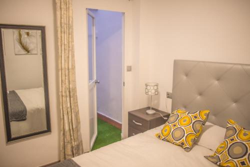 马拉加Apartamento Padilla Playa Huelin的一间卧室配有一张床、镜子和门