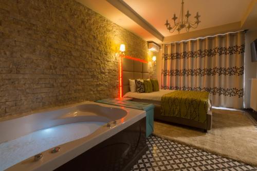 锡纳亚Romantic Jacuzzi Belleview Studio的一间带浴缸的浴室和一张位于客房内的床