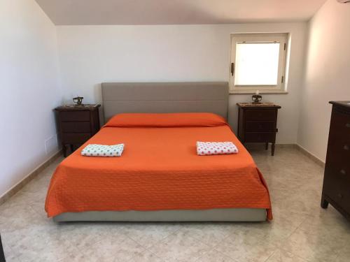 圣安吉洛Maison de Charme Iommella的一间卧室配有橙色床和两个枕头