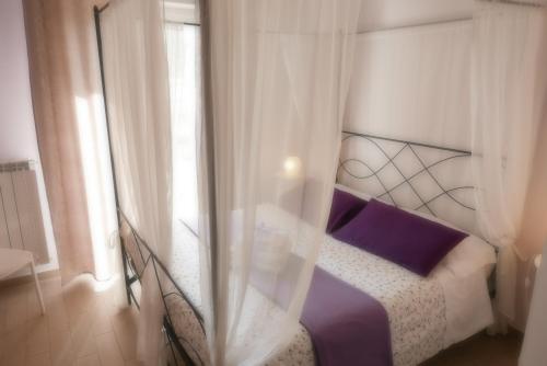 斯波托尔诺B&B Ai Tre Archi的一间卧室配有一张带紫色床单的床和窗户。