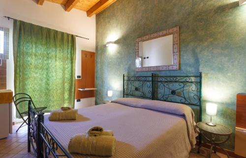 米拉佐农庄伊尔盖尔索米诺里特罗瓦塔酒店的一间卧室配有一张大床和镜子