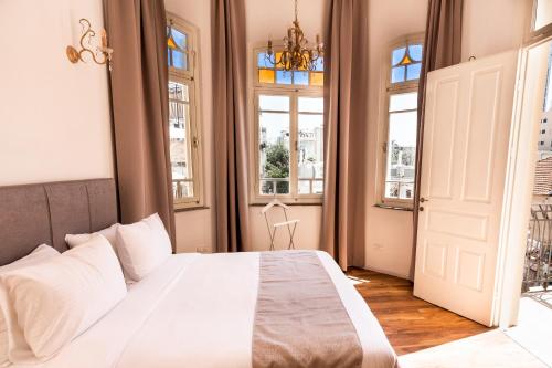 特拉维夫House of Palm - One of a Kind的卧室设有一张带窗户的白色大床