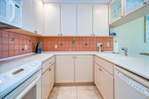 博卡格兰德Sea Oats 336 Condo的厨房配有白色橱柜和水槽
