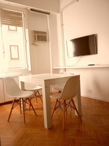 布宜诺斯艾利斯Excelente departamento en Retiro的带电视的客房内的白色桌椅