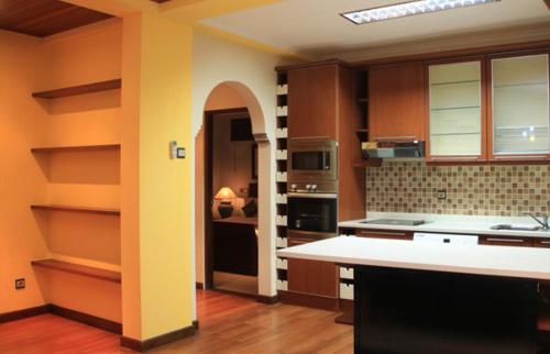 沙努尔沙努尔阿佩尔别墅酒店的厨房配有棕色橱柜和白色台面