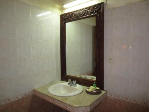 沙努尔Laghawa Beach Hotel的一间带水槽和镜子的浴室