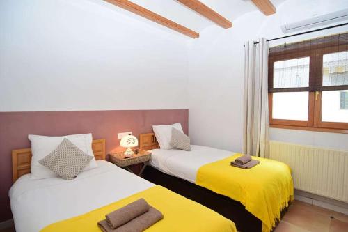 GayanesFinca Soñada - Nudist Resort的黄色和白色的客房内的两张床