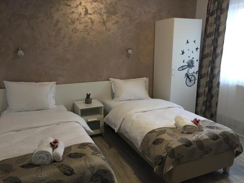 BragadiruTop Style Villa的客房内的两张床和毛巾