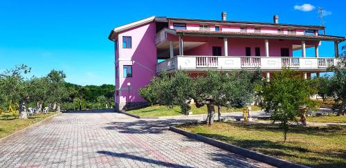 瓦斯托Villa Rita - Casa Vista Mare - Vasto Punta Penna的粉红色的建筑,在街上设有阳台