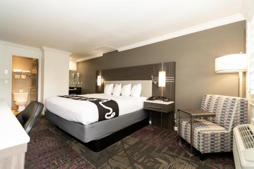 圣何塞Rodeway Inn San Jose HWY-101 Tully Rd Exit的配有一张床和一把椅子的酒店客房
