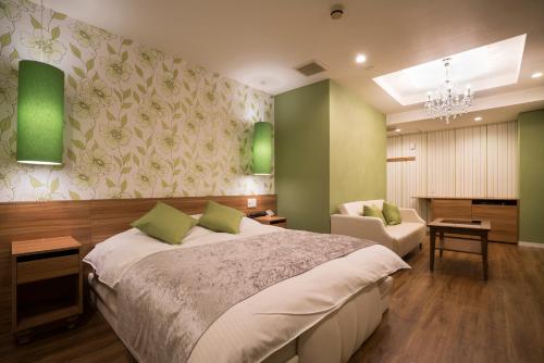 尼崎市Xenia Amagasaki的一间卧室配有一张床、一张沙发和一把椅子