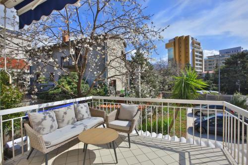 布德瓦马里内罗公寓的阳台配有沙发、两把椅子和一张桌子