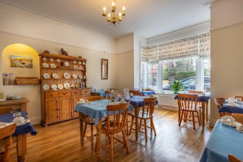 伯恩茅斯罗斯科尔特成人酒店的一间带桌椅的用餐室和窗户。