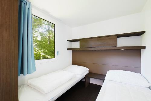 图尔恩Donaupark Camping Tulln的客房设有两张床和窗户。
