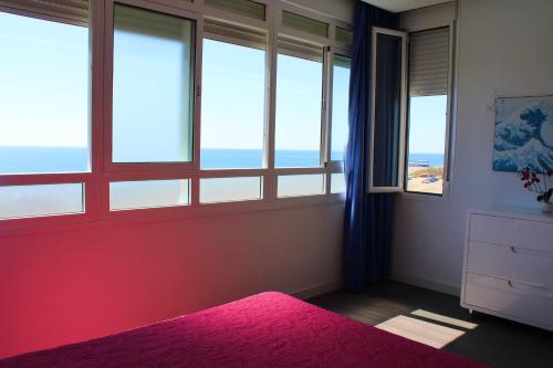 马拉加Beach Apartment Guadalmar的卧室设有窗户和粉红色地毯的粉红色床。