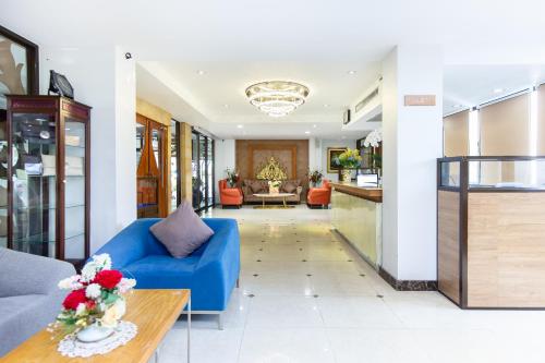 曼谷Lasalle Suites Hotel & Residence的客厅配有蓝色的沙发和桌子