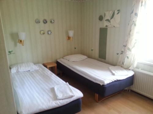 埃克勒Havsbandet Pensionat的带窗户的客房内设有两张单人床。