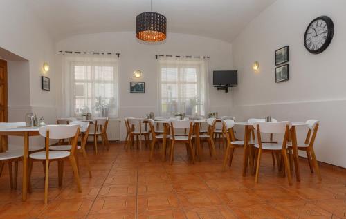 特普利采特普利采里士满酒店的一间设有桌椅的用餐室和墙上的时钟