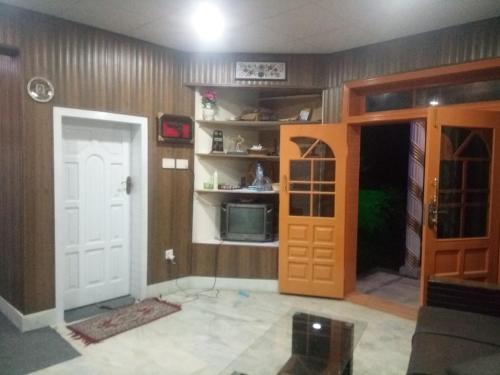 罕萨Four Seasons Guest House Hunza的一间设有门的房间和客房内的电视