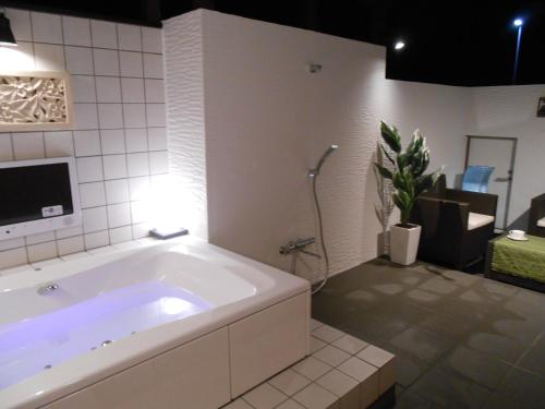 柏市Hotel Regina的浴室内设有大型白色浴缸。