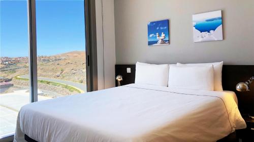 圣巴托洛梅Villa Golfers 6的卧室设有白色的床和大窗户