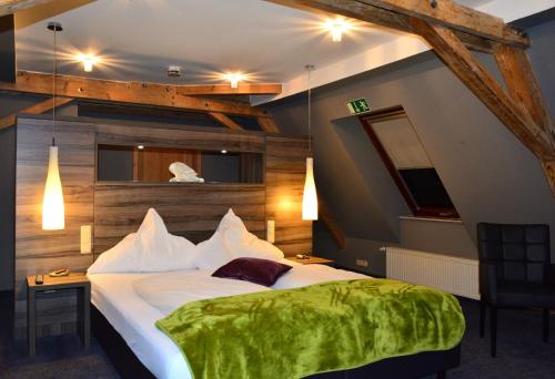 格尔斯托芬格斯索夫奥泽特酒店的一间卧室配有一张带绿毯的大床