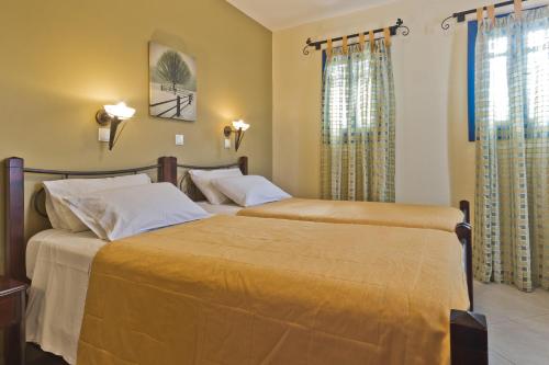 弗伊尼基昂艾尔基奥尼酒店的卧室设有两张黄色墙壁的床