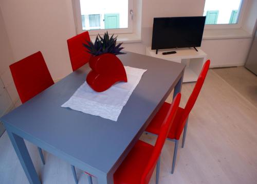 阿科La Casa di Giò的一张带红色椅子的蓝色桌子和一台电视