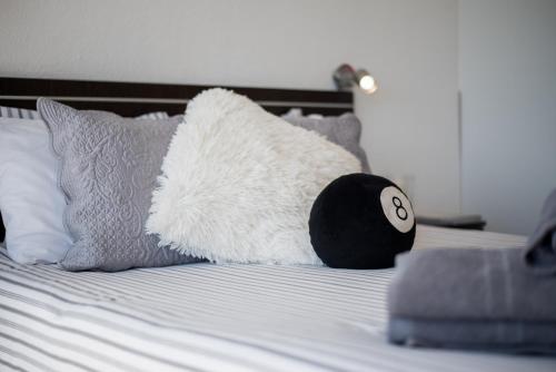 拉克鲁斯Apartamentos Estudio Nuevo en Puerto de la Cruz的一只白色填充动物躺在床上,床上有枕头